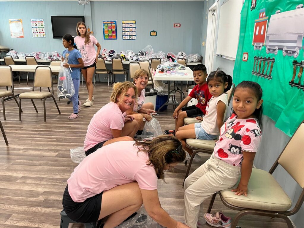 Jeanne Nealon, CEO of Laces of Love and volunteers assuring children have proper fitting shoes.